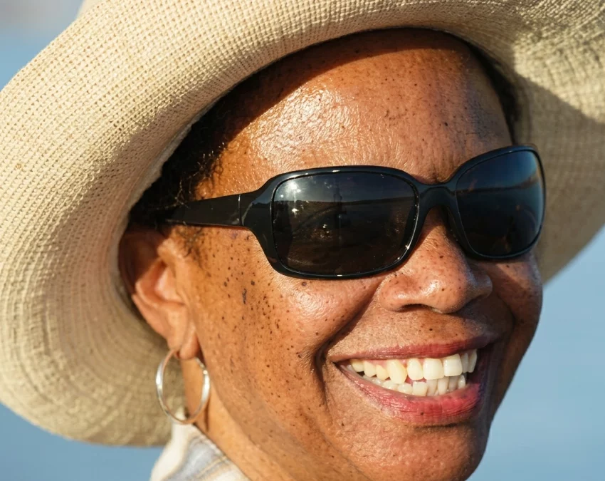 Woman with sunglasses and straw hat in the sun