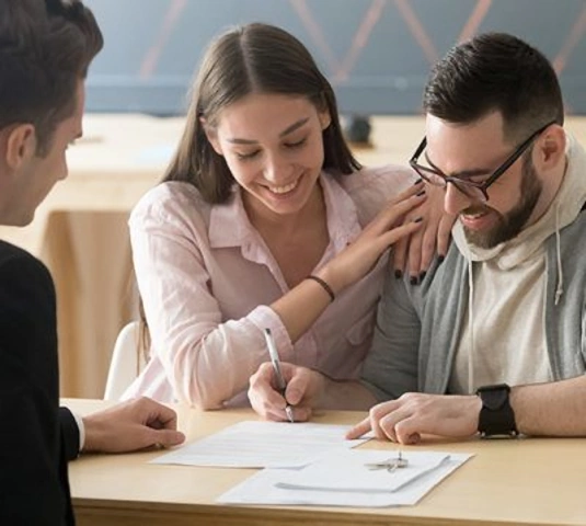 Couple signing paper in buy new home
